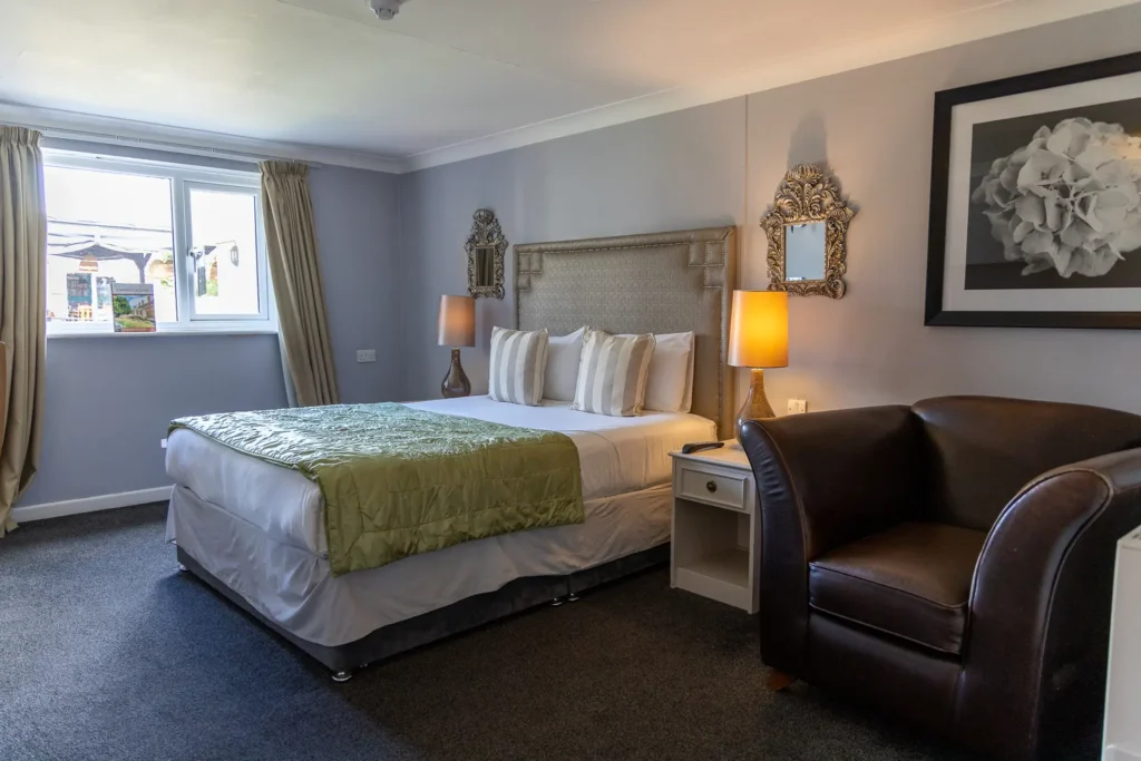 Bedroom with a green throw and leather armchair at The Old Red Lion