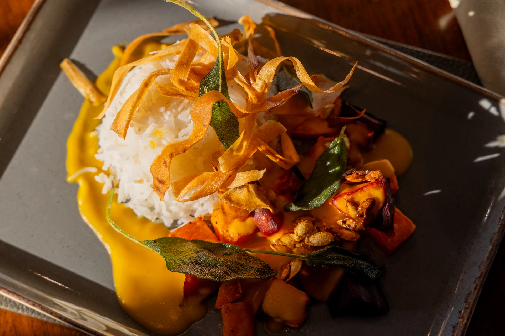 Colourful salad with roasted vegetables and a crispy topping on a glass plate at The Old Red Lion, Horseheath