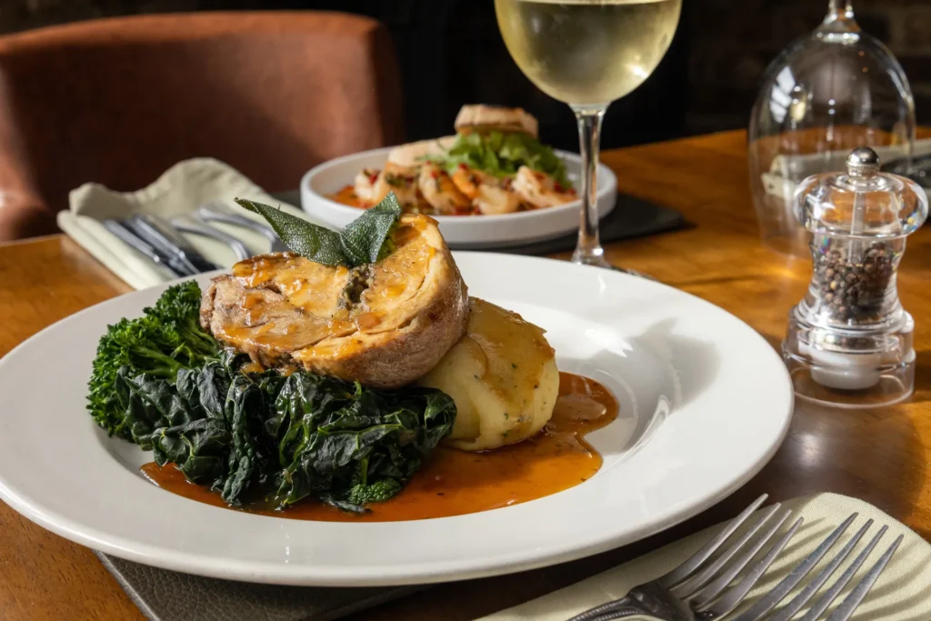 Pie with greens and gravy, served with a glass of white wine