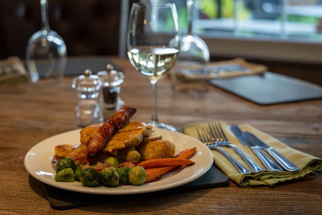 Roast dinner with Brussels sprouts and carrots on a table by the window