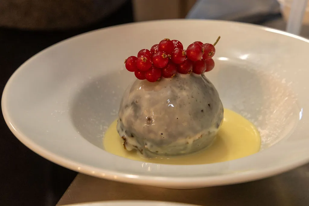 Christmas pudding with redcurrants and custard