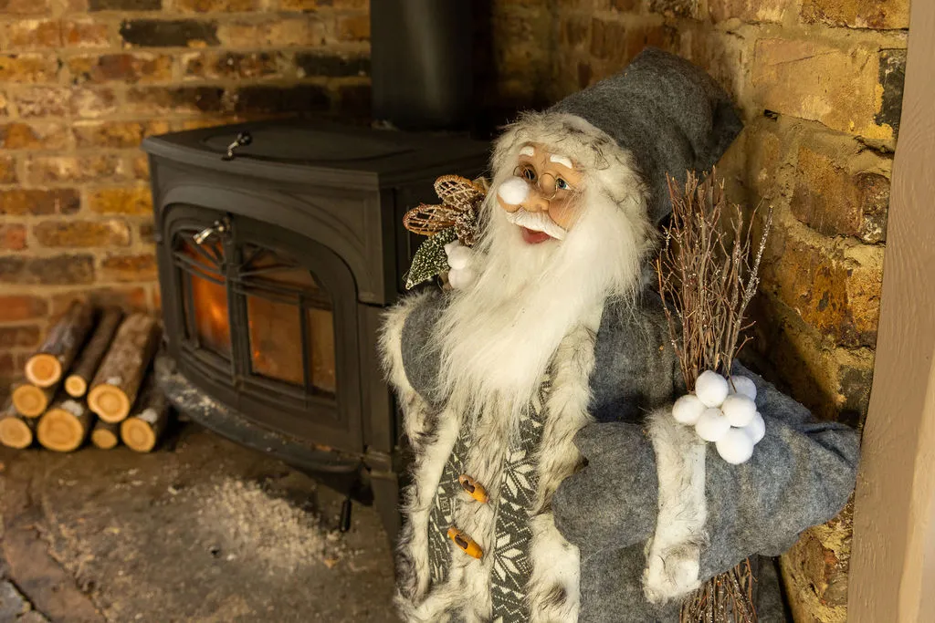 Father Christmas figure beside the wood-burning stove at The Old Red Lion, Horseheath