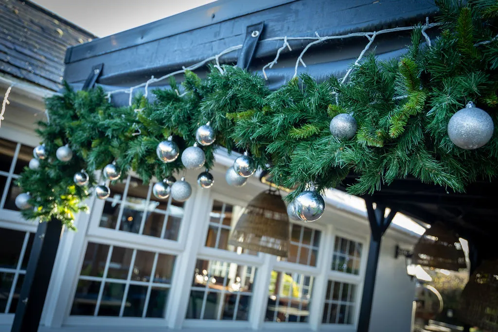 Christmas garland and lights along the outside of the pub at The Old Red Lion, Horseheath